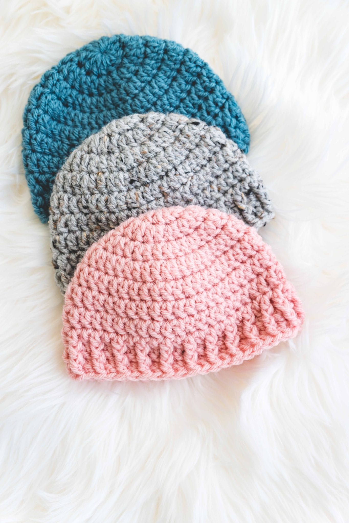 Crochet baby hat with simple stitches and gender neutral ribbing. Made in pink, blue, and grey.